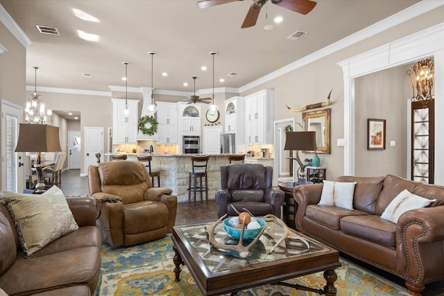 living room with ceiling fan with notable chandelier, hardwood / wood-style floors, and crown molding