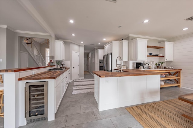 kitchen featuring kitchen peninsula, appliances with stainless steel finishes, butcher block counters, and wine cooler