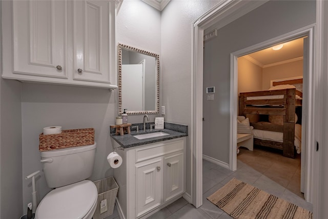 bathroom featuring toilet, vanity, crown molding, and tile patterned flooring