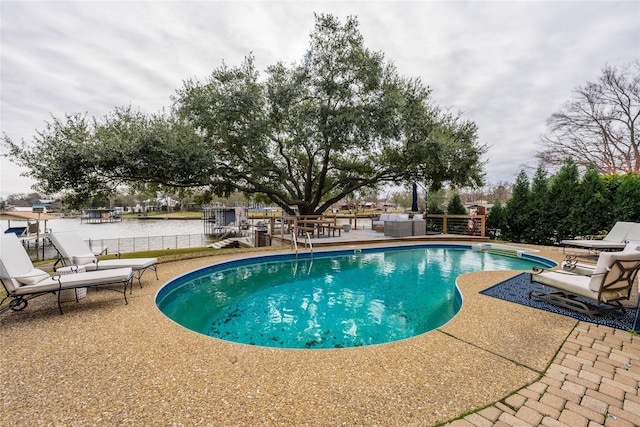 view of pool featuring a water view and a patio