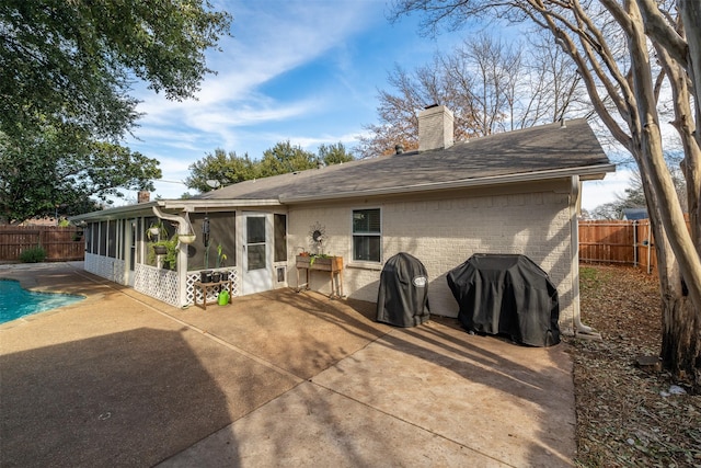 back of house featuring a fenced in pool, a patio, and a sunroom