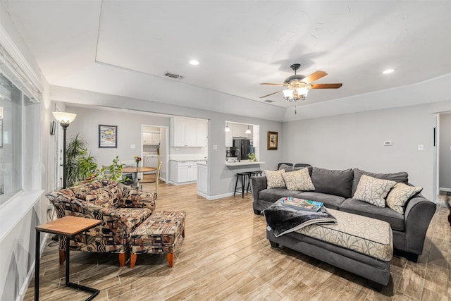 living room with ceiling fan and light hardwood / wood-style flooring