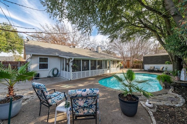 view of swimming pool with a patio and a sunroom