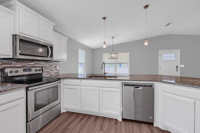 kitchen featuring tasteful backsplash, appliances with stainless steel finishes, sink, and lofted ceiling