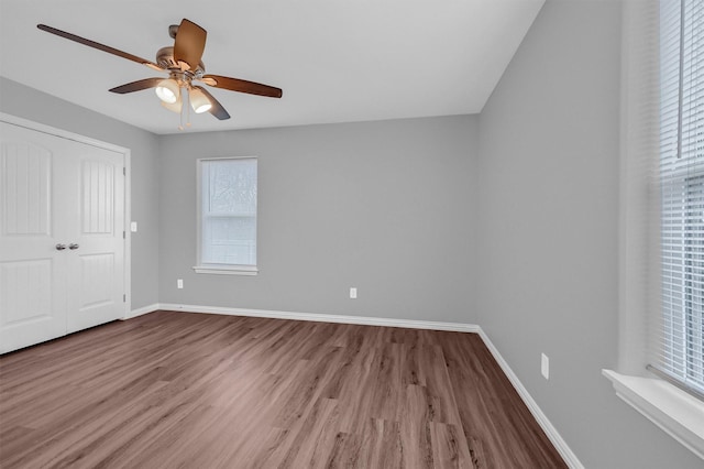 unfurnished bedroom with ceiling fan, wood-type flooring, and a closet