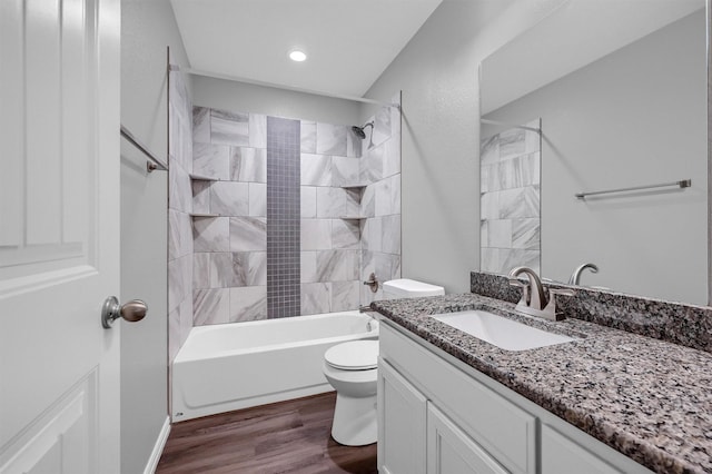 full bathroom featuring toilet, tiled shower / bath combo, wood-type flooring, and vanity