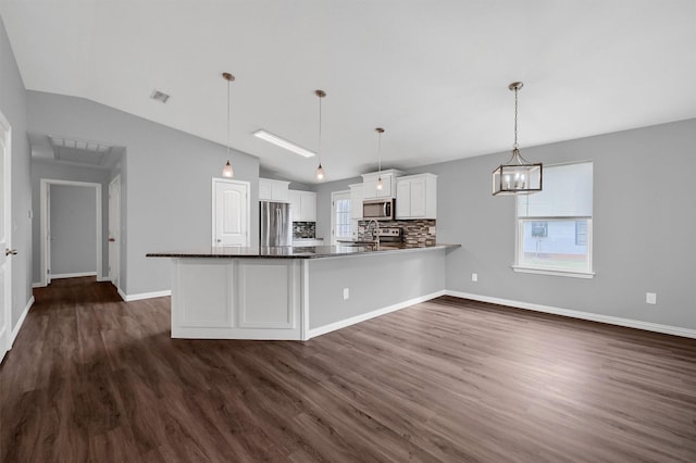 kitchen with white cabinetry, stainless steel appliances, tasteful backsplash, hanging light fixtures, and kitchen peninsula