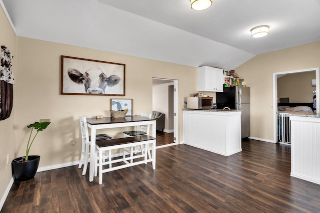 dining space with lofted ceiling and dark hardwood / wood-style floors