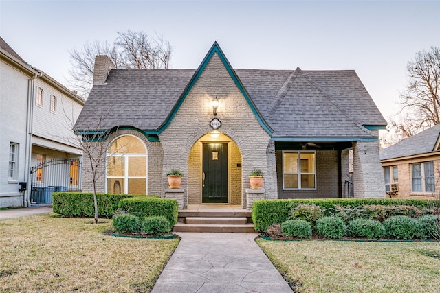 tudor home featuring a front lawn