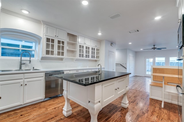 kitchen with white cabinetry, dishwasher, a center island with sink, and sink