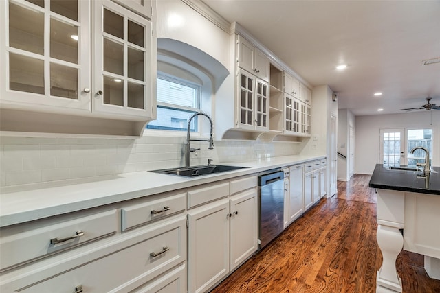 kitchen with dark wood-type flooring, sink, white cabinets, and stainless steel dishwasher