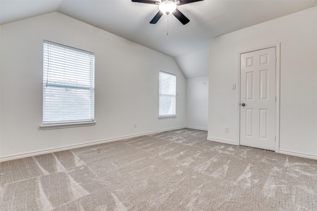 additional living space featuring ceiling fan, lofted ceiling, and light colored carpet