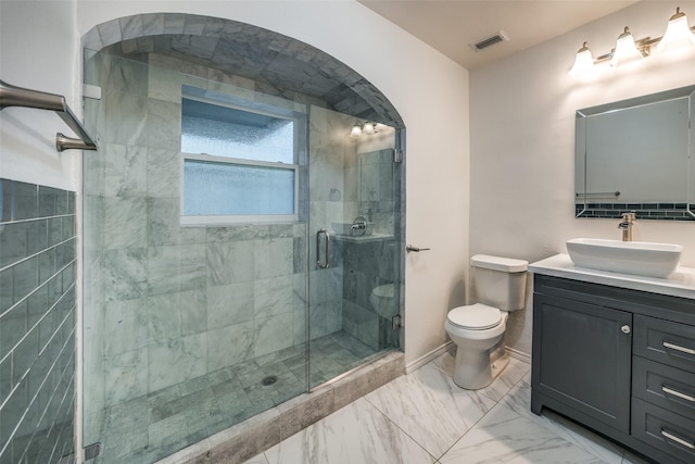 bathroom featuring toilet, a shower with door, and vanity