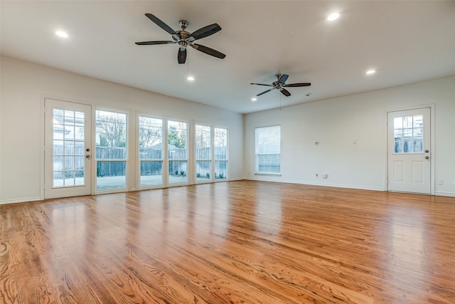 unfurnished living room with ceiling fan, a healthy amount of sunlight, and light hardwood / wood-style flooring