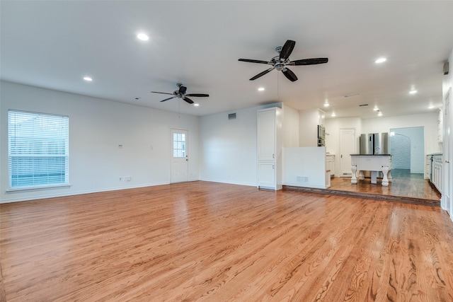 unfurnished living room featuring ceiling fan and light hardwood / wood-style flooring