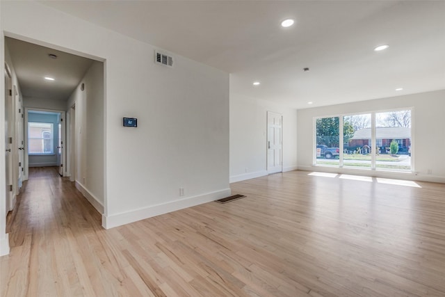 spare room featuring light wood-type flooring and plenty of natural light