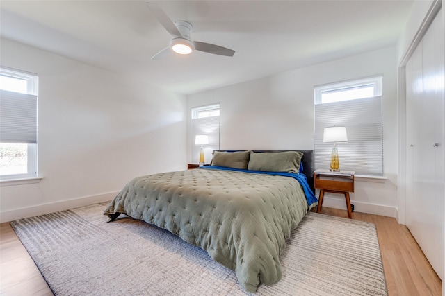 bedroom with ceiling fan, multiple windows, and hardwood / wood-style floors