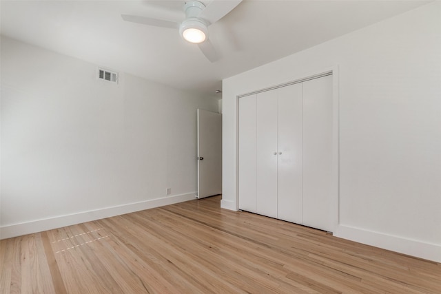 unfurnished bedroom featuring ceiling fan, a closet, and light wood-type flooring