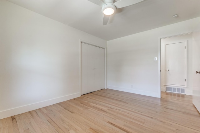 empty room with ceiling fan and light hardwood / wood-style flooring