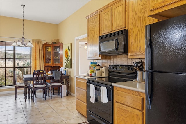 kitchen featuring tasteful backsplash, a notable chandelier, light tile patterned flooring, pendant lighting, and black appliances