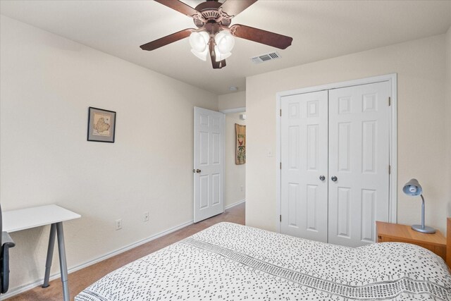 carpeted bedroom featuring ceiling fan and a closet