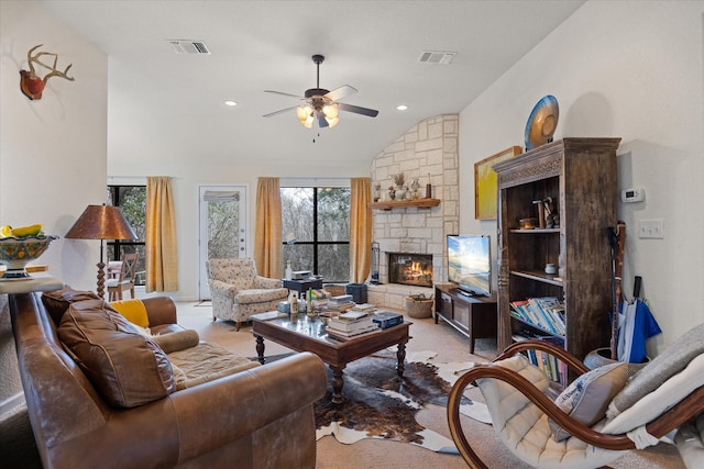 living room with vaulted ceiling, ceiling fan, and a fireplace