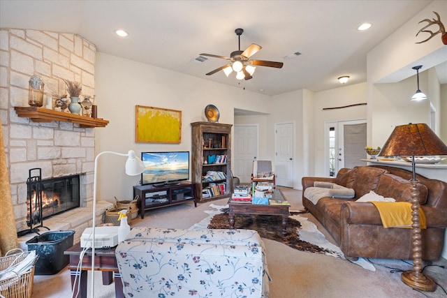 living room with ceiling fan, light colored carpet, and a stone fireplace