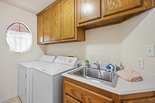 washroom with cabinets, light tile patterned floors, washer and clothes dryer, and sink