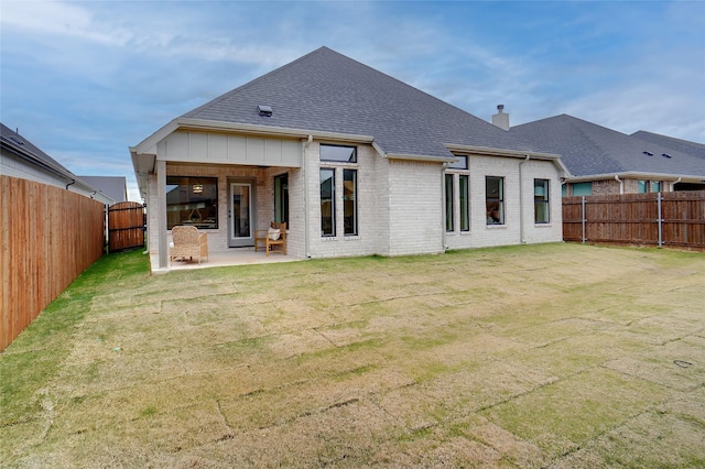 back of property with a yard and a patio