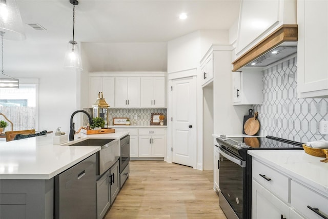 kitchen with stainless steel appliances, backsplash, white cabinetry, and hanging light fixtures