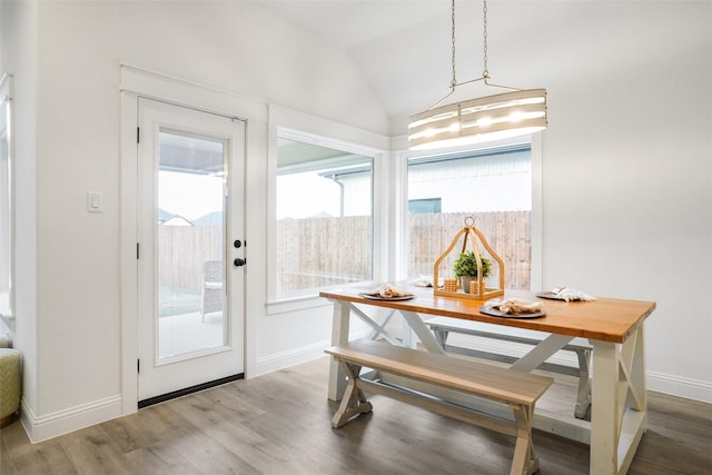 dining area featuring dark wood-type flooring and vaulted ceiling