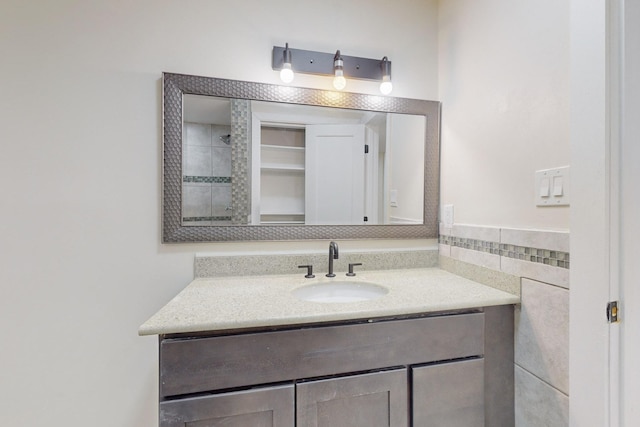 bathroom featuring vanity and tile walls