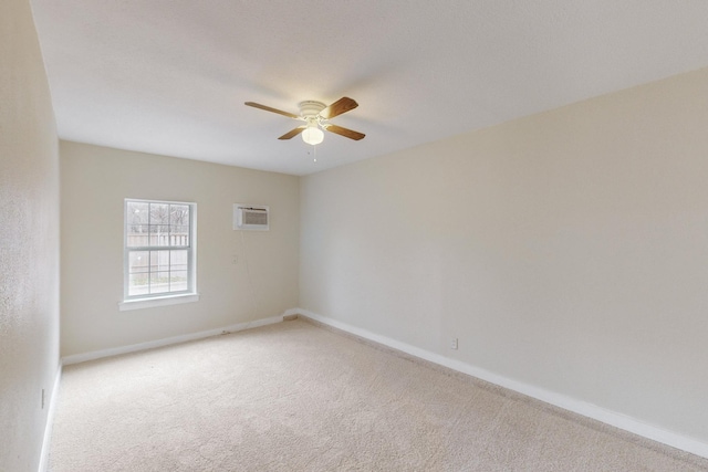 spare room with an AC wall unit, light colored carpet, and ceiling fan