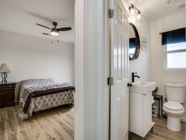 bathroom featuring toilet, ceiling fan, wood-type flooring, and vanity