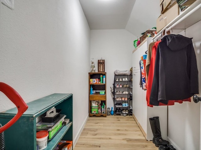 spacious closet featuring light wood-type flooring and lofted ceiling