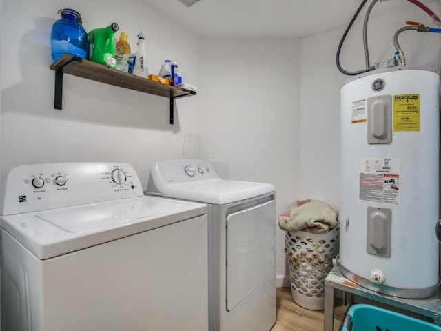 laundry room with separate washer and dryer, electric water heater, and light wood-type flooring