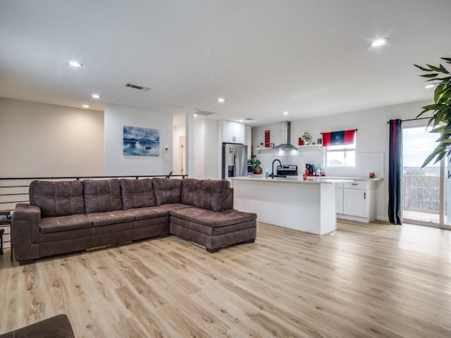 living room with light hardwood / wood-style flooring and sink