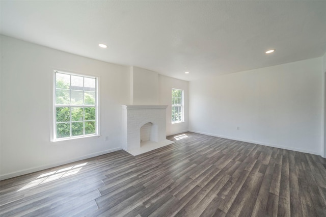 unfurnished living room featuring dark hardwood / wood-style flooring and a fireplace