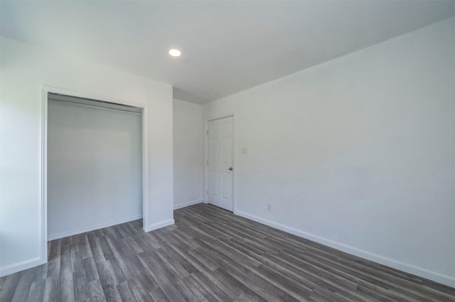 unfurnished bedroom with a closet and dark hardwood / wood-style flooring