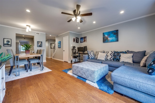 living room featuring ceiling fan, crown molding, and light hardwood / wood-style floors