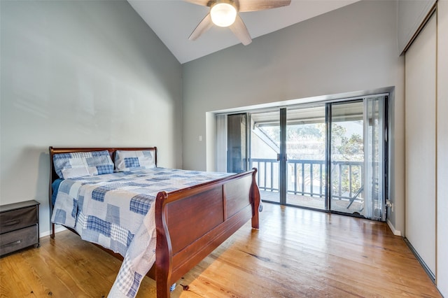 bedroom featuring ceiling fan, light wood-type flooring, a closet, access to exterior, and high vaulted ceiling