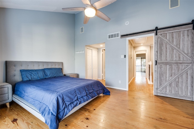 bedroom with ceiling fan, a closet, and light hardwood / wood-style flooring