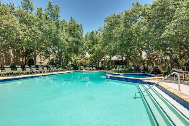 view of swimming pool featuring a hot tub