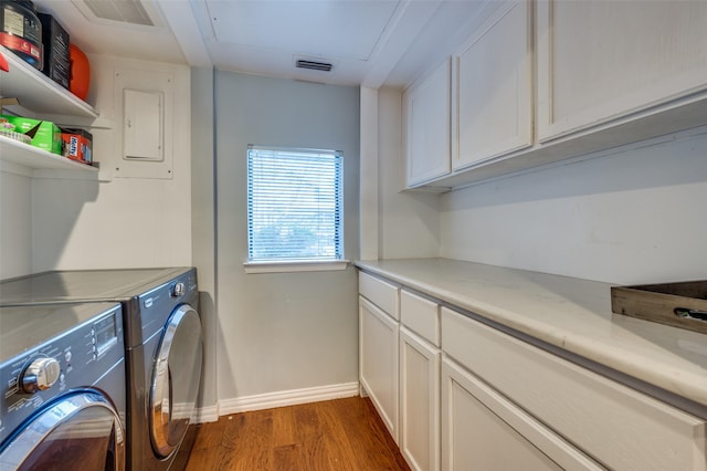 laundry room with dark hardwood / wood-style flooring, washing machine and clothes dryer, and cabinets