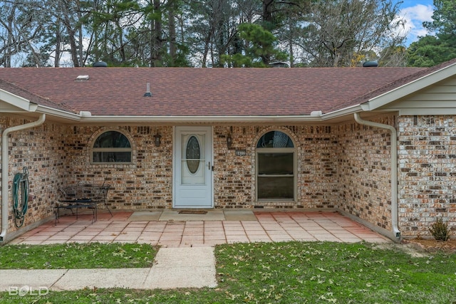 view of exterior entry with a patio area