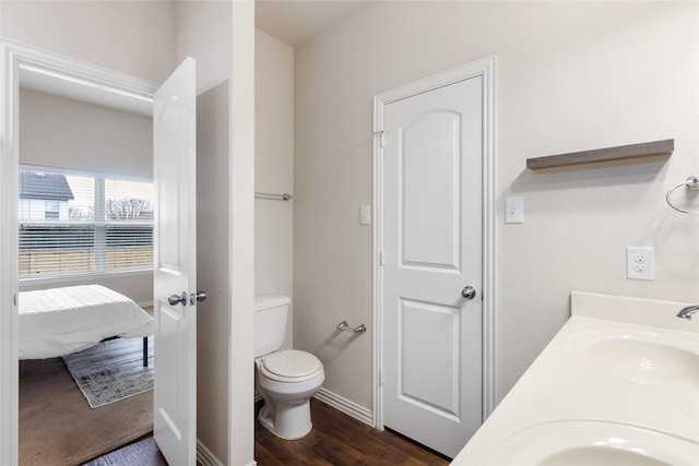 bathroom with hardwood / wood-style floors, toilet, and vanity