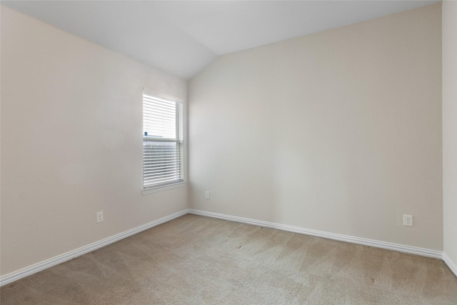 carpeted spare room with lofted ceiling