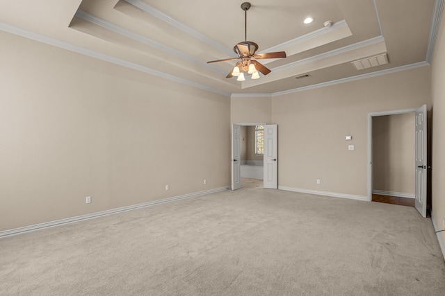 empty room with a raised ceiling and ornamental molding