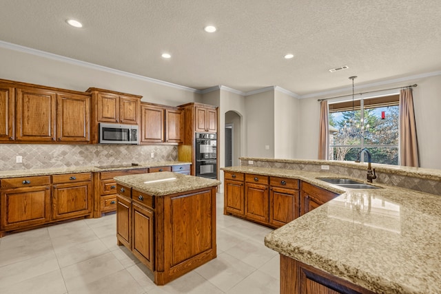 kitchen featuring sink, pendant lighting, black appliances, and crown molding