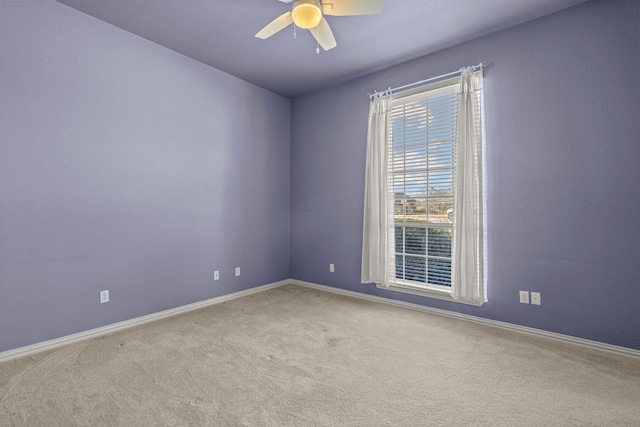 empty room featuring ceiling fan and light colored carpet